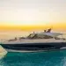 Riviera 5600 Sport Yacht lying at anchor at sunset with a guest relaxing on the bow lounge