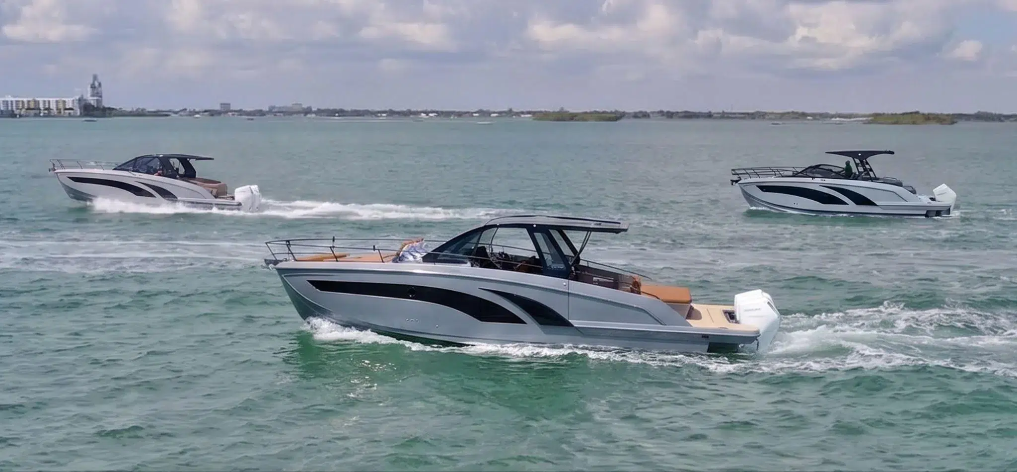Three Hanover Yachts models running on the water with skyline behind