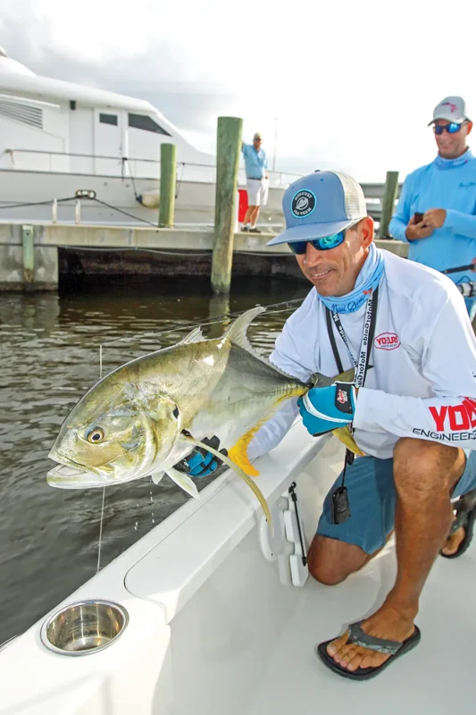 Capt. George Gouda holding the big jack crevalle he caught off the side of a boat.